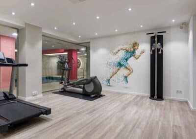 Fitnessraum mit Laufband, Crosstrainer und Poolblick im Mercure Hotel Köln Belfortstraße