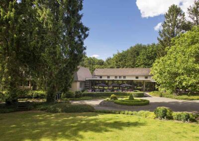 Blick auf das Bilderberg Hotel 't Speulderbos mit großem Garten und moderner Architektur