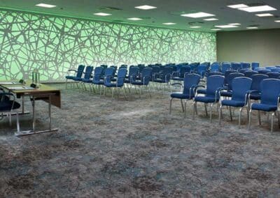 Ein moderner Tagungsraum im Bilderberg Europa Hotel, gestaltet für Konferenzen mit Reihen von Stühlen und einer lebendigen, künstlerischen Wandgestaltung.