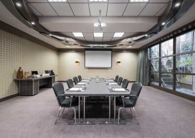 Ein Konferenzraum im Bilderberg Garden Hotel in Amsterdam, genannt "Cappuccino", eingerichtet mit einem großen Tisch, Stühlen und Präsentationsausstattung.