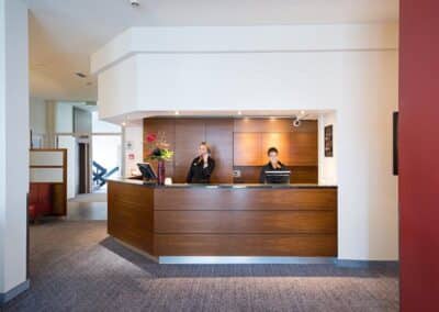 Der Empfangsbereich im Bilderberg Grand Hotel Wientjes in Zwolle, mit freundlichem Personal an der Rezeption.