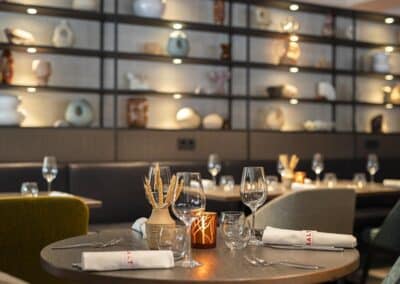 Bistro & Bar im Bilderberg Europa Hotel, mit stilvollem Dekor, Regalen mit Keramiken und einer gemütlichen Essbereich.