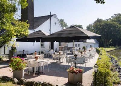 Terrasse des Bilderberg Kasteel Vaalsbroek Hotels in Süd-Limburg mit gemütlichen Sitzplätzen im Freien und Blick auf den Garten.