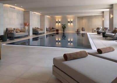 Der Innenbereich des Schwimmbads im Bilderberg Europa Hotel, mit Liegestühlen und einem ruhigen, modernen Design.