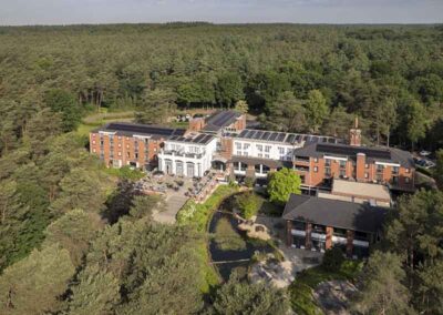 Luftaufnahme des Bilderberg Residence Groot Heideborgh Hotels, eingebettet in die Wälder der Veluwe mit Blick auf das weitläufige Gelände und die naturbelassene Umgebung.