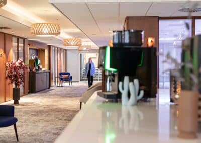 Eine Kaffeekorner im Bilderberg Europa Hotel mit Sitzgelegenheiten und einer Kaffeemaschine.