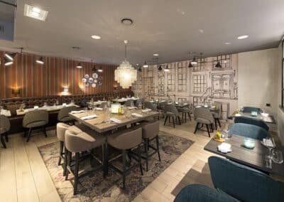 Ein weiterer Blick auf den Barbereich im Bilderberg Garden Hotel in Amsterdam, mit einer eleganten Bartheke, stilvollen Stühlen und dekorativen Elementen.