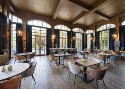 Das stilvolle Grand Café des Bilderberg Residence Groot Heideborgh Hotels, in dem Gäste eine gemütliche Zeit bei Getränken und Snacks verbringen können, umgeben von einer eleganten Innenausstattung.