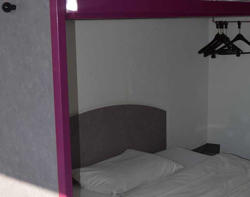 ibis Budget Hotel Berlin Hoppegarten – Kleideraufbewahrung und Bett im Zimmer