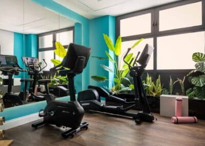 Eingangsbereich zum Mini Gym im MGallery Cerretani Florence mit Blick auf moderne Fitnessgeräte und stilvolles Interieur.